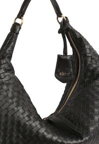 Sac à main en cuir tressé noir au design décontracté. Doté d'une fermeture éclair dorée et d'une petite étiquette en cuir avec le logo attachée à la bandoulière.