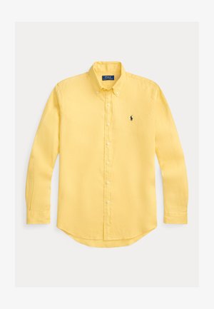 Żółta koszula na guziki z długim rękawem, wykonana z lekkiego materiału, ze spiczastym kołnierzem i zaokrąglonym dołem, z małym haftowanym logo na lewej piersi.