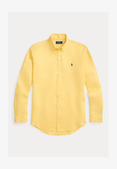 Κίτρινο πουκάμισο με μακριά μανίκια και κουμπιά, ελαφρύ ύφασμα, μυτερός γιακάς, στρογγυλεμένο τελείωμα, με μικρό κεντημένο λογότυπο στο αριστερό στήθος.