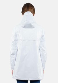 Giacca bianca, leggera e impermeabile, con cappuccio, maniche lunghe e una silhouette leggermente svasata. Texture liscia e design minimale.