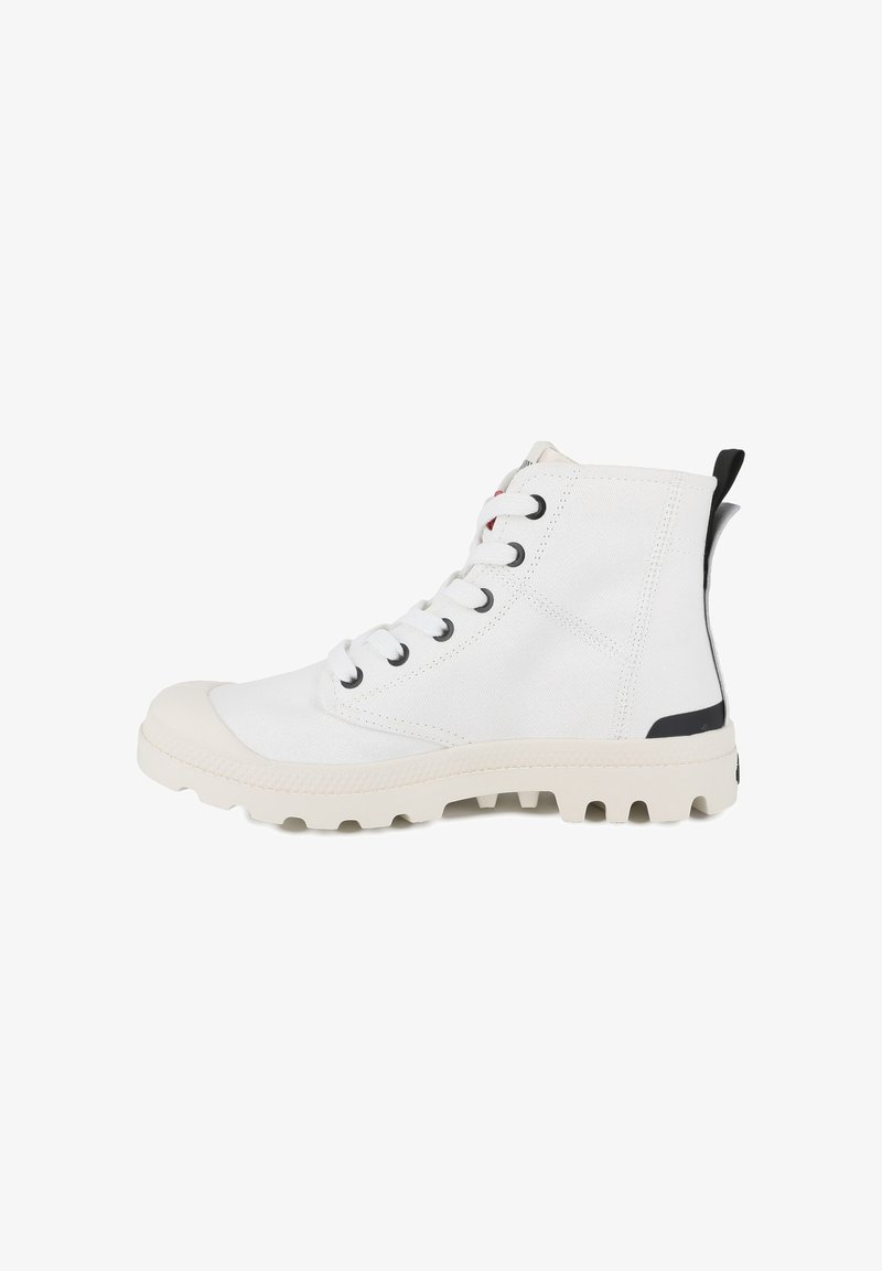 White high-top sneakers made of canvas, featuring black eyelets, white laces, and a textured rubber sole with traction nubs.