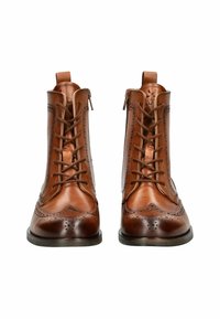 Stivaletti in pelle marrone con design allacciato, dettagli brogue e chiusura con cerniera. Presentano una texture liscia e una suola piatta e resistente.
