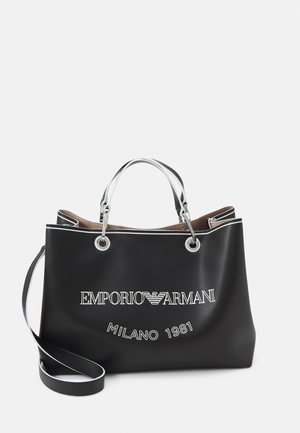 Schwarze Emporio Armani Tragetasche mit silbernen Griffen, langem Schulterriemen und weißem Logo „EMPORIO ARMANI MILANO 1981“ auf der Vorderseite.
