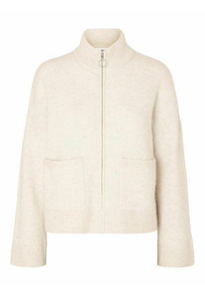 Pull crème court avec col montant, fermeture éclair avant et deux poches avant. Fabriqué en tissu tricoté doux avec des accents côtelés.