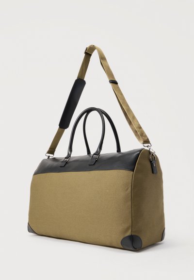 Τσάντα σακβουαγιάζ Σαββατοκύριακου σε ελιά πράσινο και μαύρο, με καφέ ρυθμιζόμενο ιμάντα ώμου και μαύρες λαβές, σε λευκό φόντο.