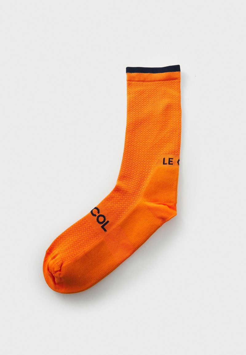 Calzino da ciclismo arancione, con un motivo testurizzato, polsino a costine in navy e logo stampato in nero. Realizzato in materiale elastico.