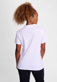 Witte polo met korte mouwen en kraag, gemaakt van lichtgewicht stof, met een eenvoudige uitstraling en een ontspannen pasvorm.