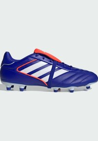 Botín de fútbol púrpura con rayas blancas y acentos rojos. Cuenta con un material sintético texturizado, una punta redondeada y tacos moldeados para mayor tracción.