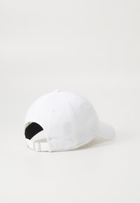 Căciulă de baseball albă, ajustabilă, cu o coroană rotunjită, vizieră curbată și o curea Velcro în spate. Textură netedă și design minim.