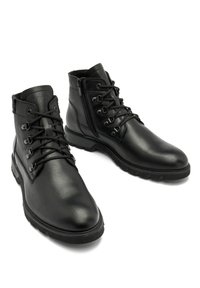 Czarne skórzane botki za kostkę z okrągłym noskiem, sznurowanym przodem i zamkami błyskawicznymi po bokach. Podeszwa ma teksturowanie dla lepszej przyczepności i trwałości.