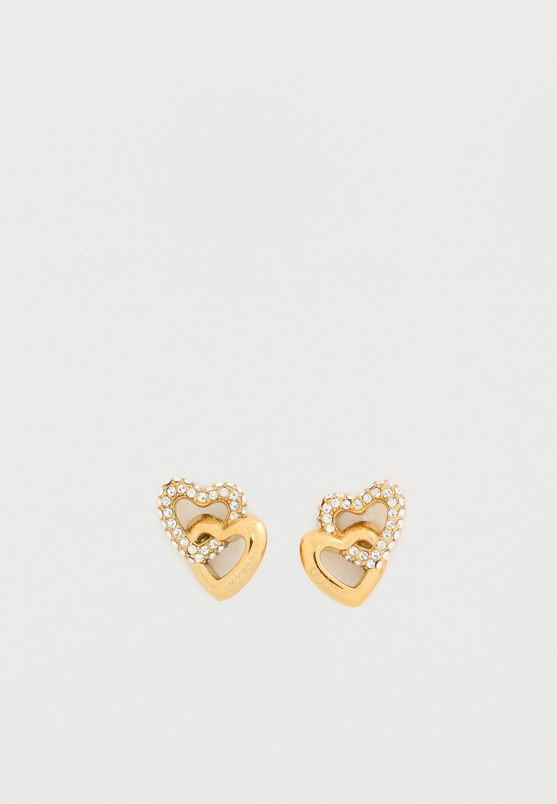 Σκουλαρίκια σε σχήμα καρδιάς από χρυσό με μια μικρότερη καρδιά στη μέση, διακοσμημένα με διάφανα στρας γύρω από την εξωτερική άκρη. Λεπτό και απαλό φινίρισμα.