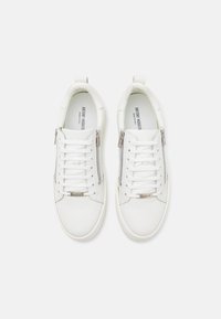 White leather sneakers with a smooth texture, featuring laces and a side zipper. A metal logo accent appears on the tongue.
