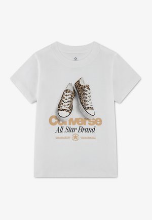 T-shirt blanc à manches courtes avec un motif de baskets imprimé léopard et texte "Converse All Star Brand" en police beige et noire.