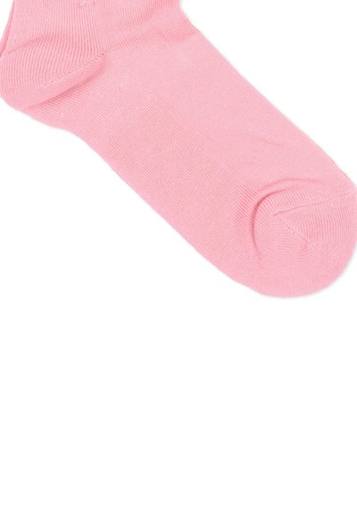 Zachte roze enkelsok plat gelegd, met geribbelde boord, hiel en teen stiksels op een witte achtergrond.