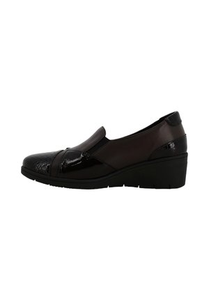 Scarpe slip-on nere con pannelli lisci e testurizzati, una finitura lucida e un tacco a basso wedge con suola imbottita.