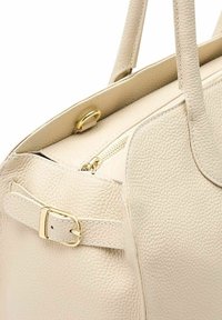 Beige leren handtas met een gestructureerde afwerking, voorzien van een gouden rits en hardware, aangevuld met een gespdetail aan de zijkant.