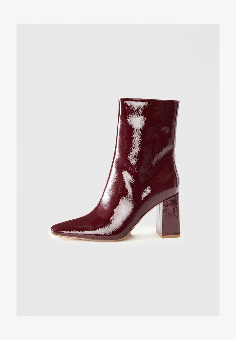 Burgundowe, lakierowane botki za kostkę z ostrym noskiem i słupkiem z przezroczystym akcentem. Gładka textura i błyszczące wykończenie.