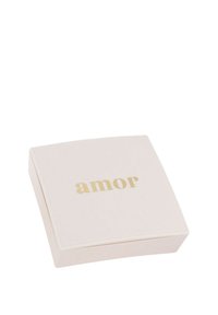 Kwadratowe, jasnoróżowe pude�łko o matowym wykończeniu. Na wieczku znajduje się napis "amor" w złotym kolorze. Elegancka i gładka tekstura, minimalistyczny design.