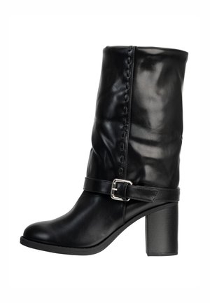 Sort læderstøvle til midt på læggen med blokhæl og dekorativ rem med sølvspænde rundt om anklen.