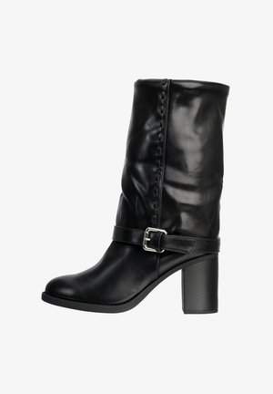 Sort læderstøvle til midt på læggen med blokhæl og dekorativ rem med sølvspænde rundt om anklen.