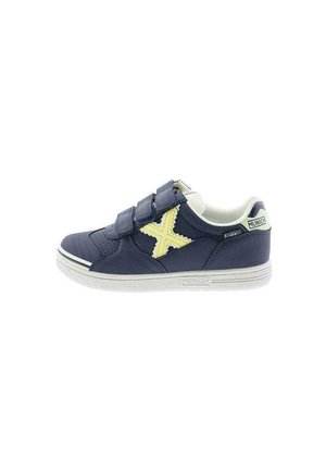 Zapatilla de deporte azul marino con dos tiras de velcro, suela blanca y detalle en cruz amarillo. Cuenta con tejido texturizado y acentos en contraste.