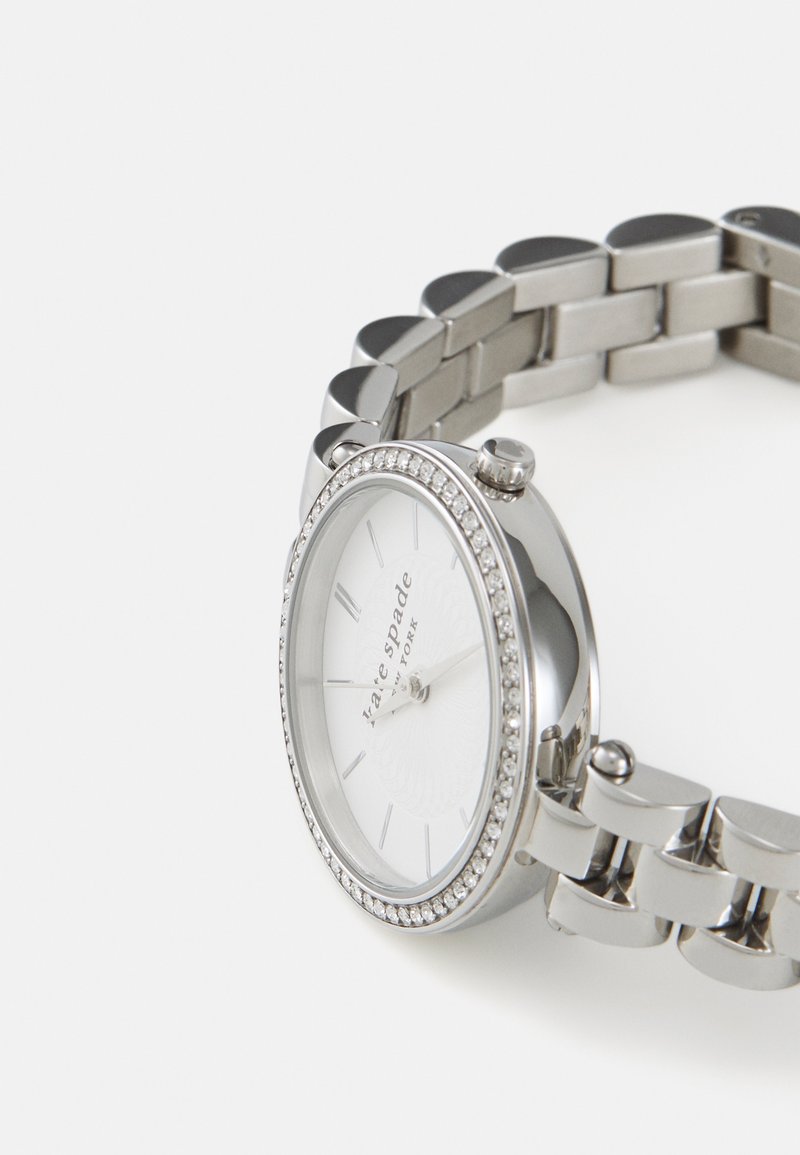 Orologio argento con quadrante rotondo, dial bianco e dettagli in cristallo sulla lunetta, dotato di un bracciale a maglie.