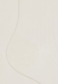 Ingrandimento di un tessuto a coste di colore crema con area del tallone rinforzata, che mostra la texture e il motivo a maglia dei calzini.