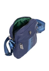 Laivastonsininen olkalaukku kestävästä kankaasta, jossa on vihreä vuori, vetoketjulla suljettava päällinen ja säädettävä olkahihna, jossa on logokoristeet.