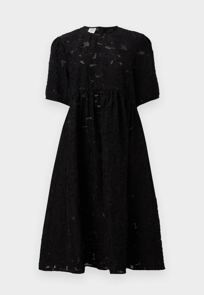 Vestuário preto feito de tecido texturizado com mangas curtas, decote redondo e um cós franzido, caindo logo abaixo do joelho.