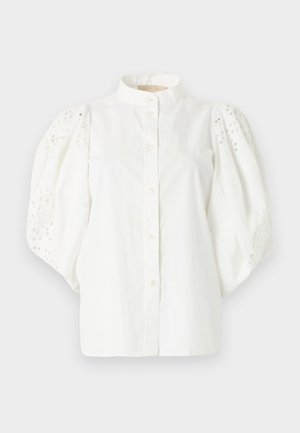 Λευκό μπλουζάκι με φουσκωτά μανίκια από δαντέλα με μικρές οπές, όρθιο γιακά και κούμπωμα με κουμπιά μπροστά.