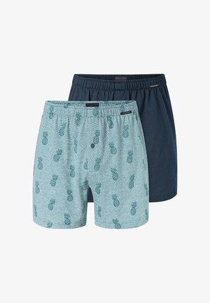 Zwei Boxershorts; eine hellblau mit Ananasmuster, die andere einfarbig marineblau. Beide haben elastische Bündchen und einen Knopfleistenverschluss.