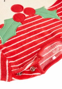 Rød- og hvidstribet babybodystocking med blød tekstur, prydet med broderede grønne kristtornblade og røde bær, og med trykknapper i bunden.