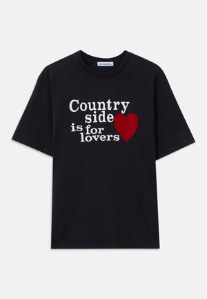 Schwarzes T-Shirt mit kurzen Ärmeln und weißem Text "Landleben ist für Liebhaber" sowie einer roten Herzgrafik auf der Vorderseite.