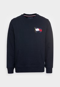 Donkerblauwe sweatshirt van katoen, met een voorkangeroezak, geribbelde manchetten en een geborduurd vlagontwerp op de borst.