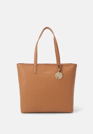 Bordowa syntetyczna torba na ramię o teksturowanym wykończeniu, z dwoma mocnymi uchwytami, złotą logo oraz okrąłym charmsą przymocowanym z boku.