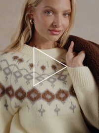 Kreemjas kampsun, mis on valmistatud kootud kangast, millel on pruunides ja hallides toonides geomeetrilised mustrid. Soonikkoes varrukasääred ja ümmargune kaelus. Pehme tekstuur.