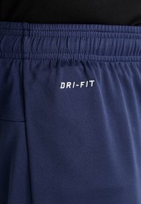 Navy athletic shorts featuring a textured fabric, elastic waistband, and "DRI-FIT" logo in white embroidery on the front.