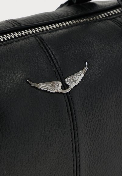Μαύρη δερμάτινη τσάντα με ασημένιο έμβλημα φτερωτού σχεδίου, λεπτομερείς ραφές και μεταλλικό φερμουάρ στην επάνω άκρη. Υφή επιφάνειας.