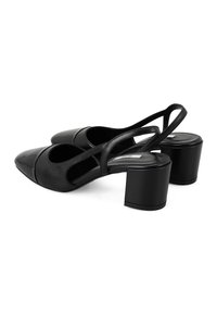 Chaussures slingback en cuir noir avec un bout pointu, des côtés découpés et un talon épais pour la stabilité et le confort. Texture lisse sur l'ensemble.