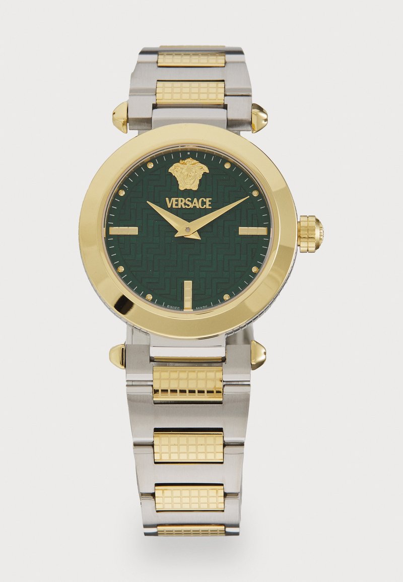 Versace-klocka med en grön mönstrad urtavla, guldaccenter, armband i rostfritt stål och guldton, samt en framträdande lejonlogotyp kl 12.