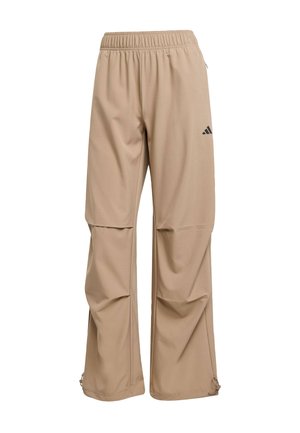 Beige Sporthose aus glattem Stoff mit elastischem Bund, Logodetail und Reißverschlussöffnungen am Saum zur Anpassung.