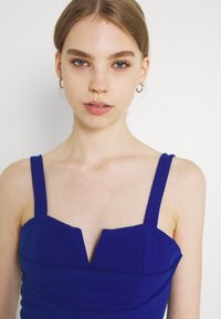 Vestido azul royal com alças largas, corpete estruturado e decote em V. Tecido suave e silhueta ajustada.