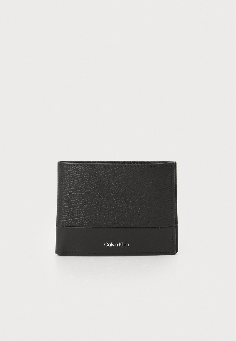Svart lommebok laget av teksturert lær med en glatt base, med en subtil Calvin Klein-logo på forsiden. Kompakt og rektangulært design.