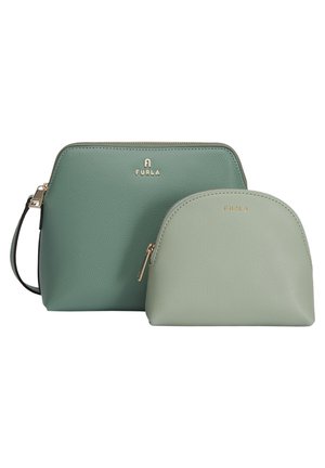 Zwei grüne Furla Lederbeutel mit goldenen Reißverschlüssen, einer größer mit Handgelenksriemen und einer kleiner, beide mit strukturierter Oberfläche und Markenlogos.