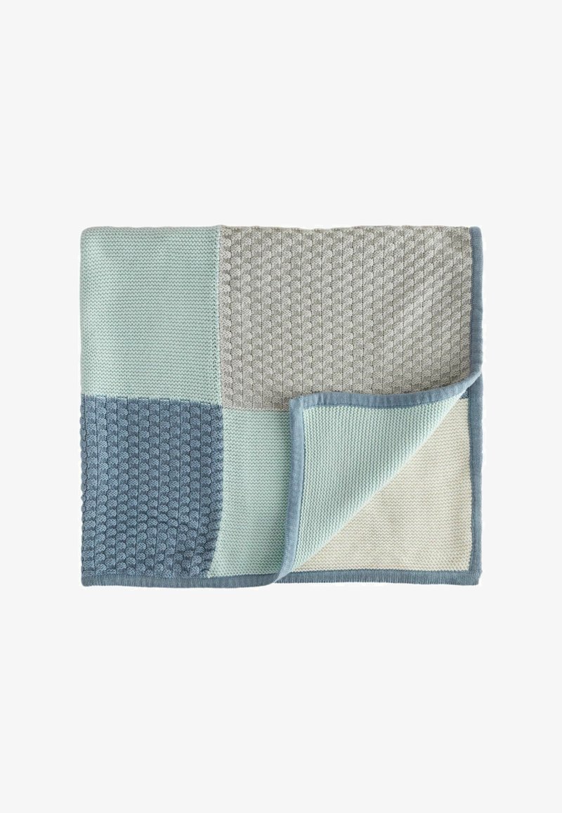 Kötött takaró, amely foltvarrásos mintával rendelkezik, puha kék, mentazöld és világosszürke színekben. Texturált és sima részek, kontrasztos kerettel.