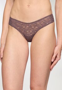 Slip bikini in un delicato mauve, caratterizzato da intricati motivi floreali e una morbida cintura elastica. Materiale leggero e trasparente.
