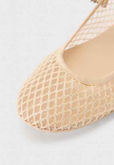 Πλατφόρμα μπεζ με πάνω μέρος από γυαλιστερό δίχτυ διαμαντιού και στρογγυλεμένη μύτη, εμφανίζεται σε κοντινό πλάνο σε ανοιχτό γκρι φόντο.