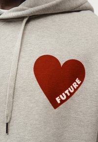 Sweat à capuche gris avec un grand cœur rouge et le mot « FUTURE » en blanc, en tissu texturé et avec un cordon de serrage.