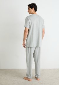 Grijs katoenen lounge-outfit met een T-shirt met korte mouwen en broek met elastische tailleband, met een ontspannen pasvorm en omgeslagen enkels.