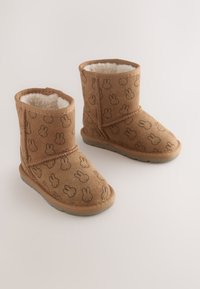 Braune Stiefeletten mit Hasenmustern, weichem Innenfutter und flacher Gummisohle. Hergestellt aus wildlederähnlichem Material mit gesteppten Details.